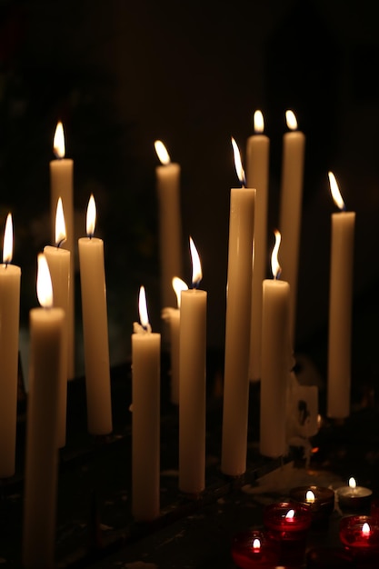 Foto close-up van brandende kaarsen in de donkere kamer