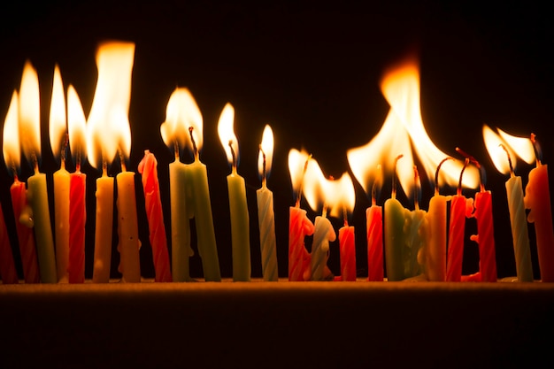 Foto close-up van brandende kaarsen op tafel in de donkere kamer