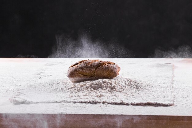 Foto close-up van brood op tafel tegen een zwarte achtergrond