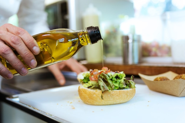 Close-up van chef-kok die brood met gehaktballen in een voedselvrachtwagen voorbereidt.