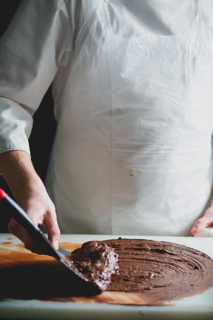 Foto close-up van chef-kok die chocolade dessert maakt