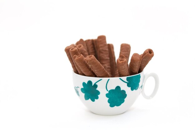 Close-up van chocolade snacks in een koffiebeker tegen een witte achtergrond