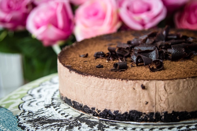 Close-up van chocoladekoek door roze rozen