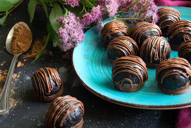 Close up van chocoladetruffels op blauwe plaat lepel met cacaopoeder zoet dessert