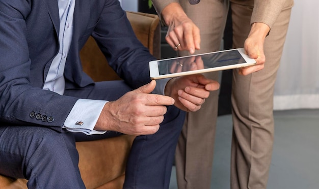 Close-up van collega's die aan het bureau staan met laptop en praten