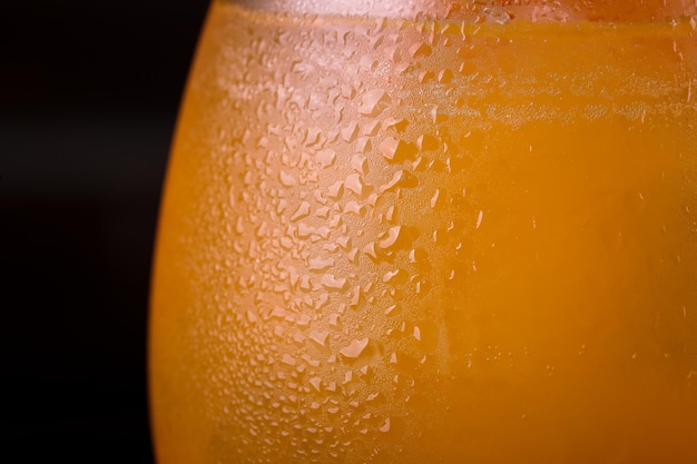 Foto close-up van condens op glas met sinaasappel drank