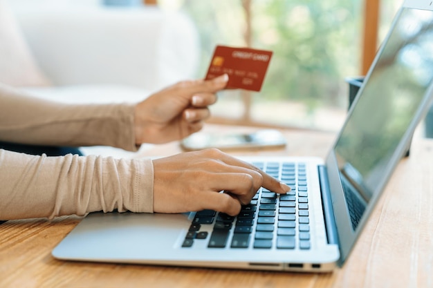 Close-up van creditcardgebruik voor online betalen, bankieren en winkelen op het internetnetwerk met laptopcomputer met creditcardtechnologie voor het online opwaarderen van beveiligde portemonnees en cruciale aankopen