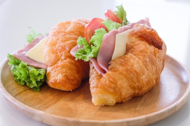 Close-up van croissants en met vlees en salade op een houten bord