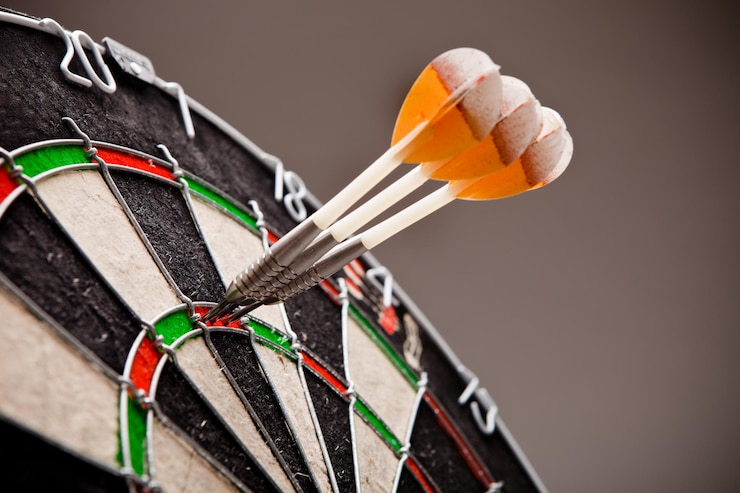 Foto close-up van darts aan boord tegen een grijze achtergrond