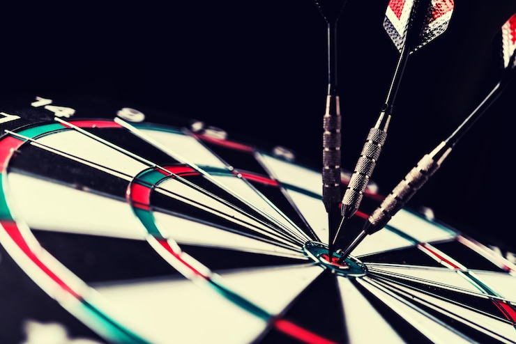 Foto close-up van darts op het doel tegen een zwarte achtergrond