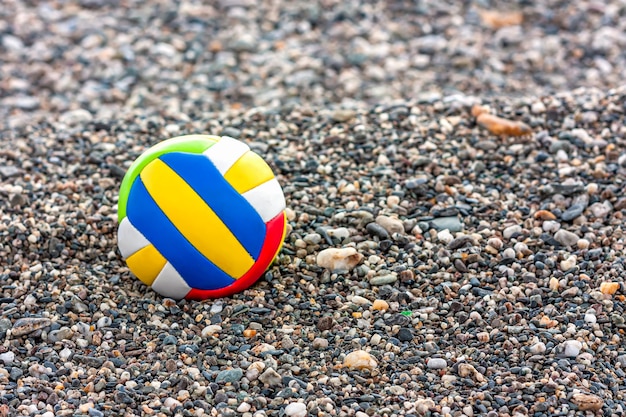 Close-up van de bal van het gekleurde kind op een kiezelstrand zee. Zomer strandspellen.