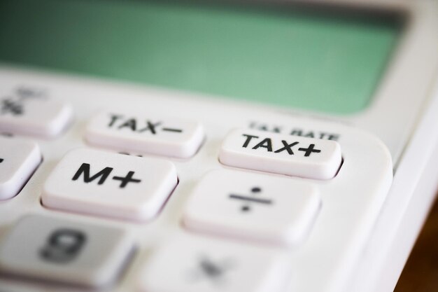 Foto close-up van de belastingknop op zakelijke witte rekenmachine