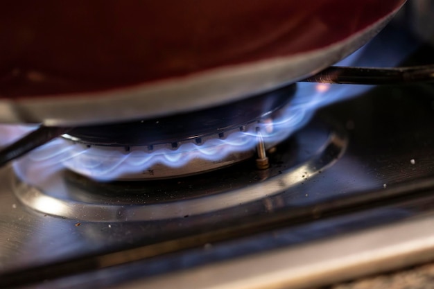 Close-up van de blauwe vlam van een huishoudelijke kachel die het gasverbruik en de energiekosten symboliseert