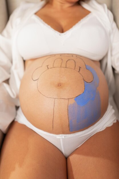 Close-up van de buik van een zwangere vrouw die wordt geverfd