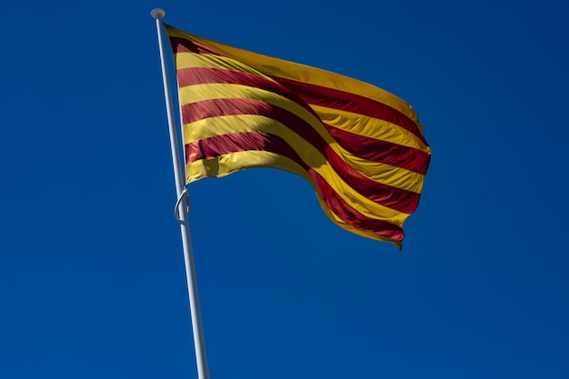 Close-up van de Catalaanse vlag die in de blauwe lucht vliegt