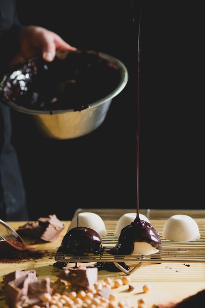 Close-up van de chef-kok die chocolade op het dessert druppelt