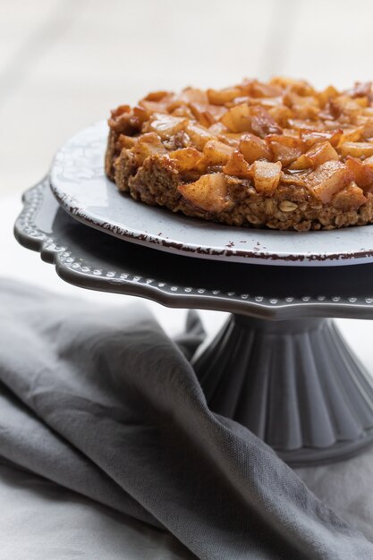 Close-up van de crumble van de peer en van de appel op een caketribune. Veganistische glutenvrije cake met amandelmeel.