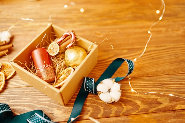 Close-up van de doos van de gift van Kerstmis en decoraties op houten tafel Nieuwjaar sfeer candy cane kaars...