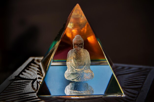 Foto close-up van de glazen piramide met gegraveerd boeddha hologram erin