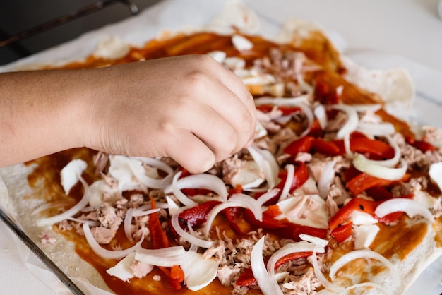 Foto close-up van de hand die pizza bereidt