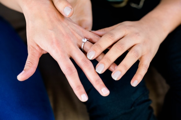 Close-up van de hand die van de vrouw een ring op haar partnersvinger zet