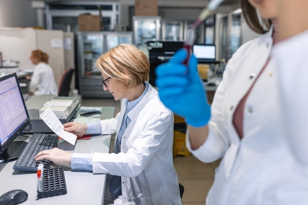 Close-up van de hand in handschoen met behulp van micropipet tijdens het werken met reageerbuisjes Mensen in innovatief farmaceutisch laboratorium met moderne medische apparatuur voor genetisch onderzoek