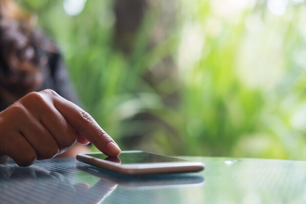 Close-up van de hand met behulp van een smartphone buiten