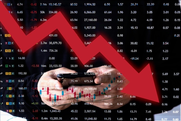 Close-up van de hand met behulp van tablet met financiële cijfers en neerwaartse rode pijl op onscherpe achtergrond