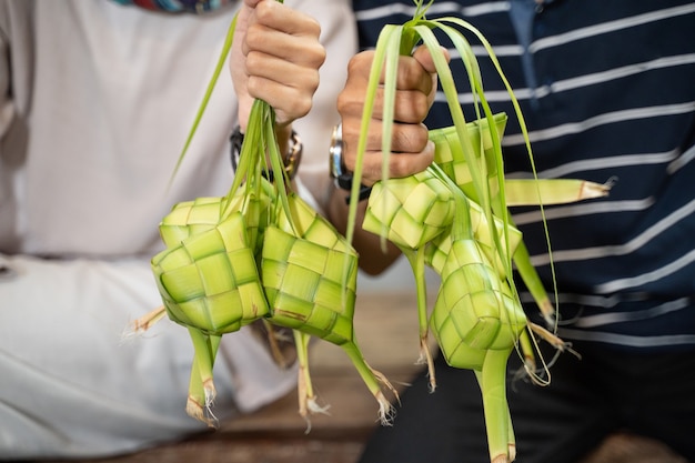 Close-up van de hand met ketupat met kokosblad