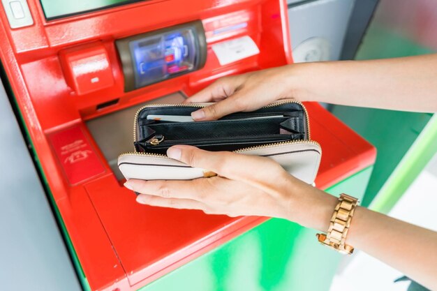 Close-up van de hand met portemonnee het opnemen van contant geld bij ATM machine financiën geld bank en mensen concept