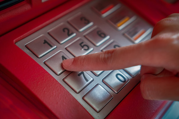 Close-up van de hand te drukken en de verborgen code verborgen bij het opnemen van het geld via ATM