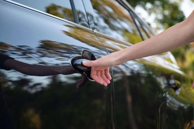 Close-up van de hand van de bestuurder die de voordeur van de auto opent met touch ID vingerafdruk scantechnologie Voertuigveiligheidsconcept