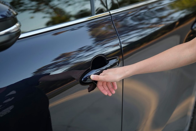 Close-up van de hand van de bestuurder die de voordeur van de auto opent met touch ID vingerafdruk scantechnologie Voertuigveiligheidsconcept