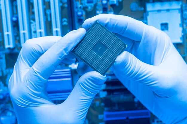 Foto close-up van de hand van de wetenschapper die een cpu-processorchip vasthoudt, werkend in het laboratorium