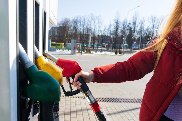 Close-up van de hand van een jonge vrouw die een tankpistool vasthoudt