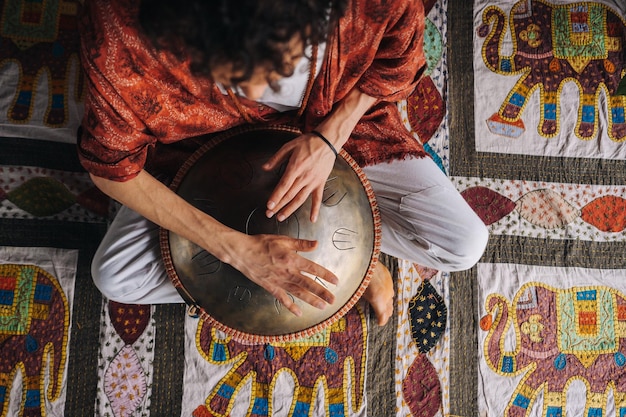 Foto close-up van de hand van een man die een modern muziekinstrument bespeelt, de orion reed drum