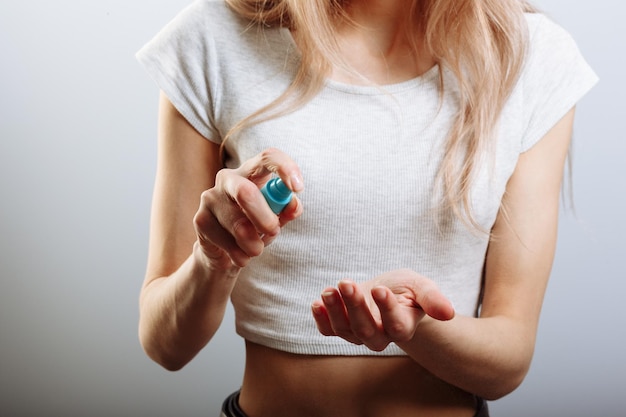 Close-up van de hand van een mooie vrouw die persspray-alcohol doet om het virus te steriliseren