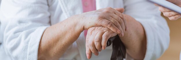 Foto close-up van de hand van een oudere vrouw die een spoorweg vasthoudt