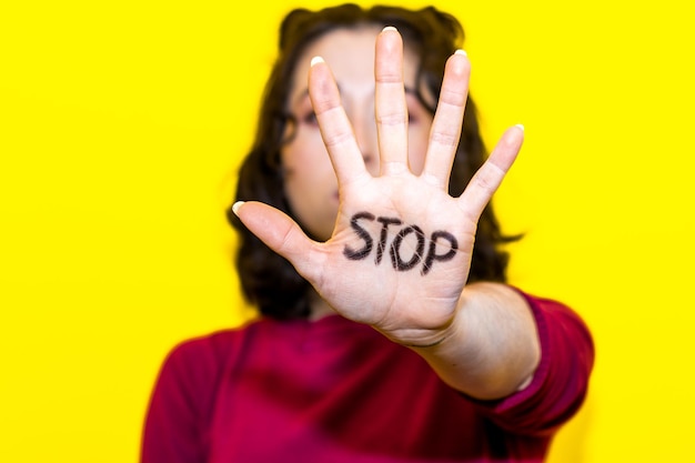 Foto close-up van de hand van een vrouw met het woord stop erop geschreven concept van strijd en gelijkheid van vrouwenrechten vrouwendag