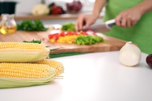 Close-up van de handen van de vrouw koken in de keuken Huisvrouw die verse salade snijdt