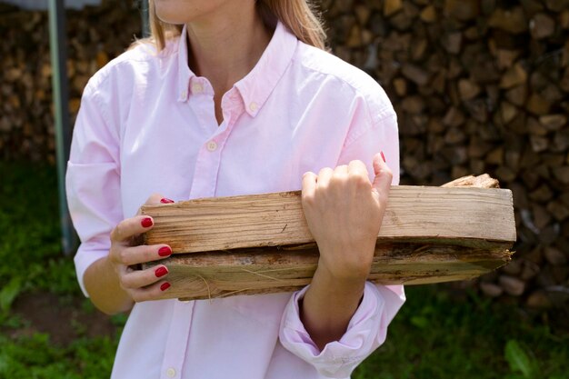 Close-up van de handen van de vrouw met brandhout Het huis verwarmen met hout