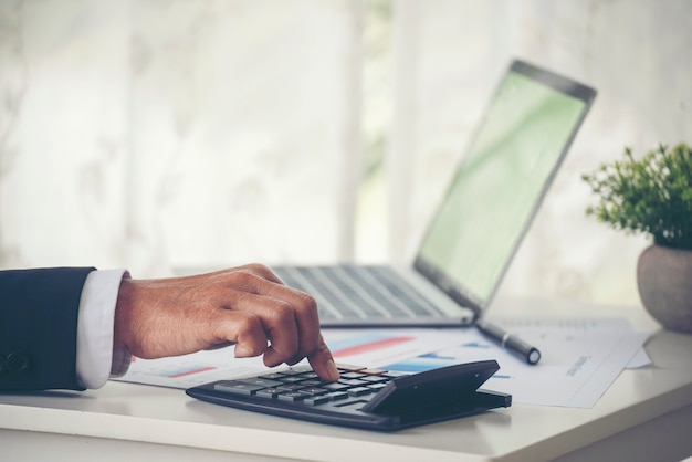 Close-up van de handen van de zakenman met behulp van een rekenmachine die de financiële rekening van de belasting telt Belastingcontrole Financieel concept