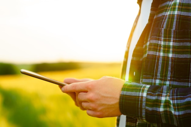 Close-up van de handen van een boer met een tablet in het veld Boekhouding van uitgaven en inkomsten op de boerderij Eco-producten