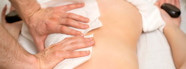 Close-up van de handen van een masseur met handdoekmassage