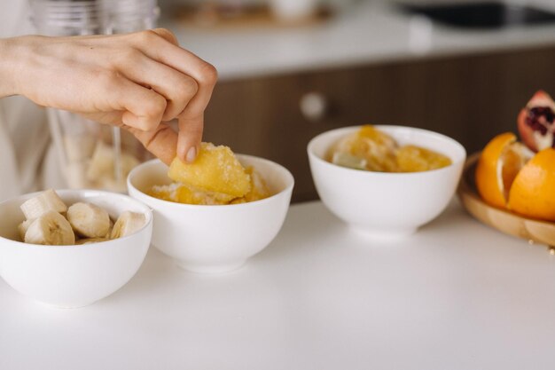 Close-up van de handen van een meisje dat een detoxcocktail van fruit maakt in de keuken Dieet voor gewichtsverlies