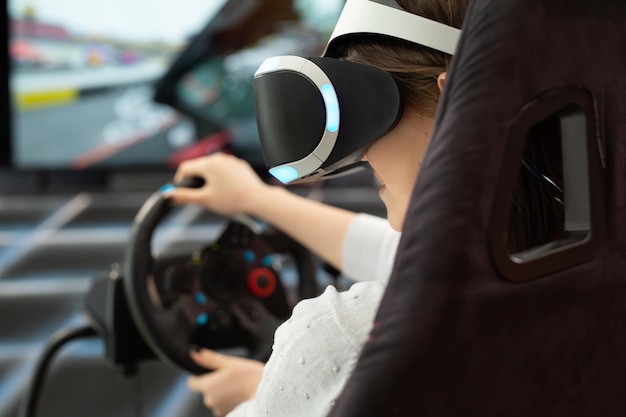 Close-up van de handen van een tienermeisje in virtual reality-bril die het stuur vasthoudt