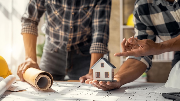 Close-up van de handen van ingenieursteams die modelhuis maken Ingenieursteams die op kantoor werken