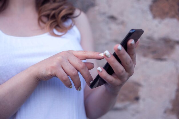 Foto close-up van de handen van vrouwen die een mobiele telefoon vasthouden