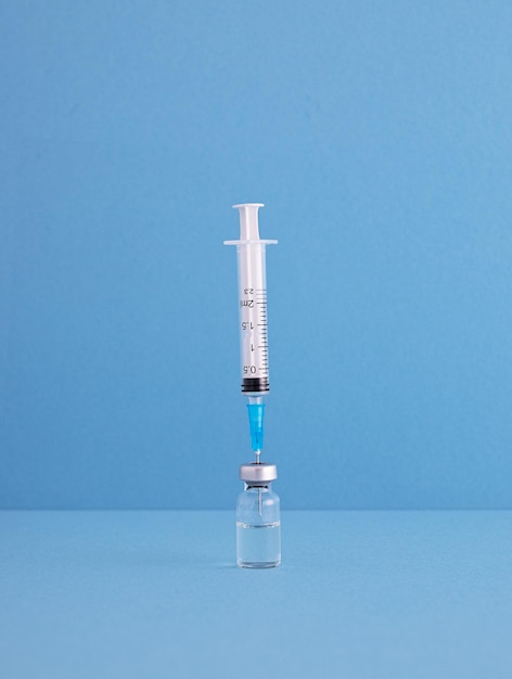 Close-up van de injectiespuit met injectieflacon op blauwe achtergrond