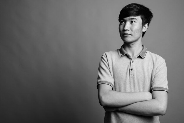 Close-up van de jonge Aziatische man met grijs poloshirt